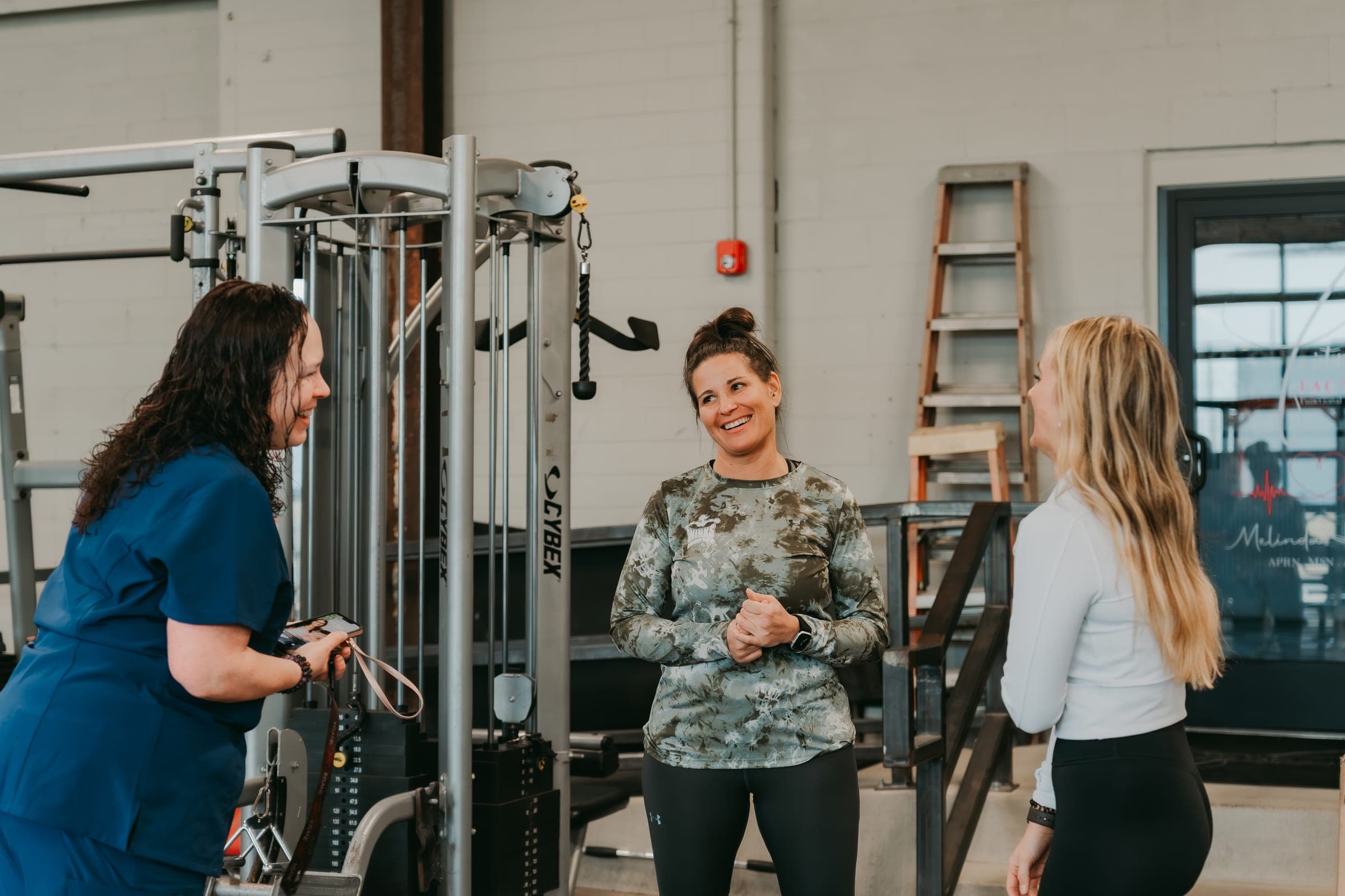 Mindy Hickey, APN talking with clients at The Fitness Factory